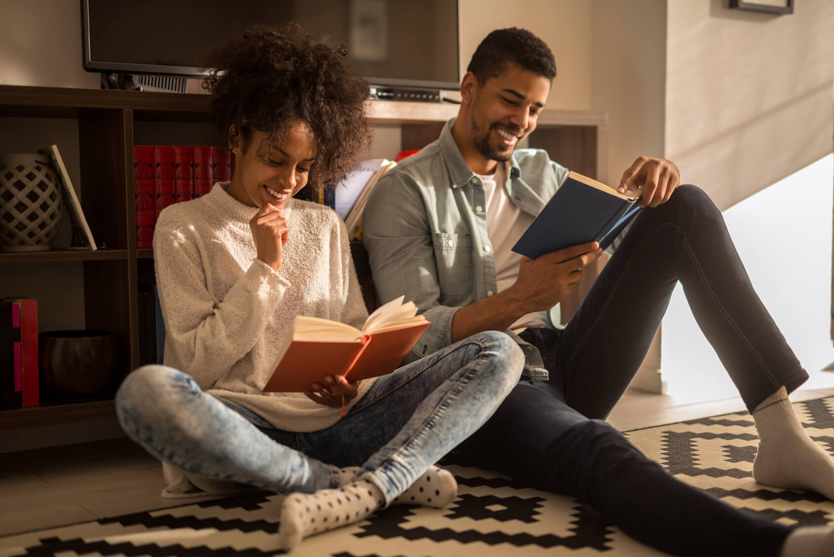 African american couple enjoying reading together at home.